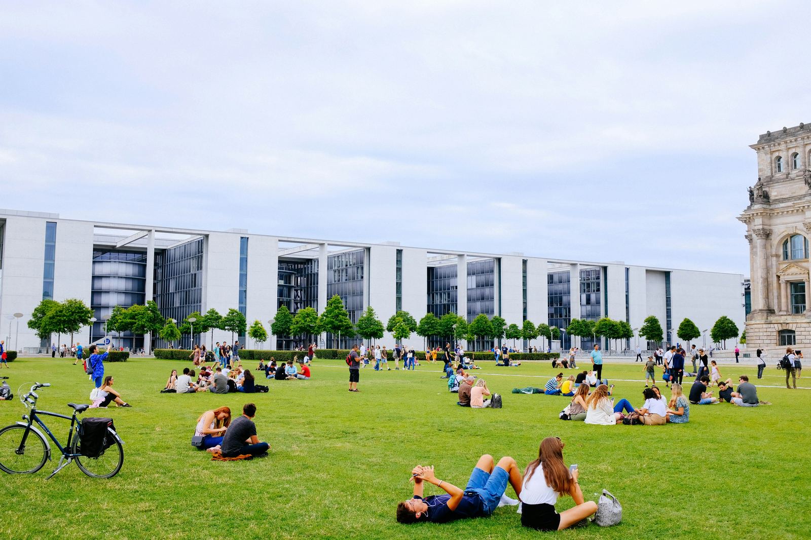 Modern government building surrounded by a lawn where people relax